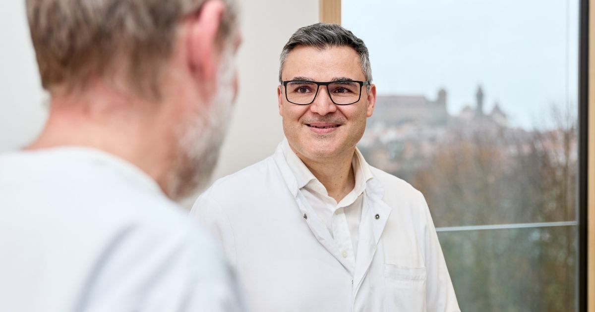 Dr. med. Dimitrios Vlachos im Gespräch mit einem Patienten in der Hüftsprechstunde der DR. ERLER KLINIKEN Nürnberg