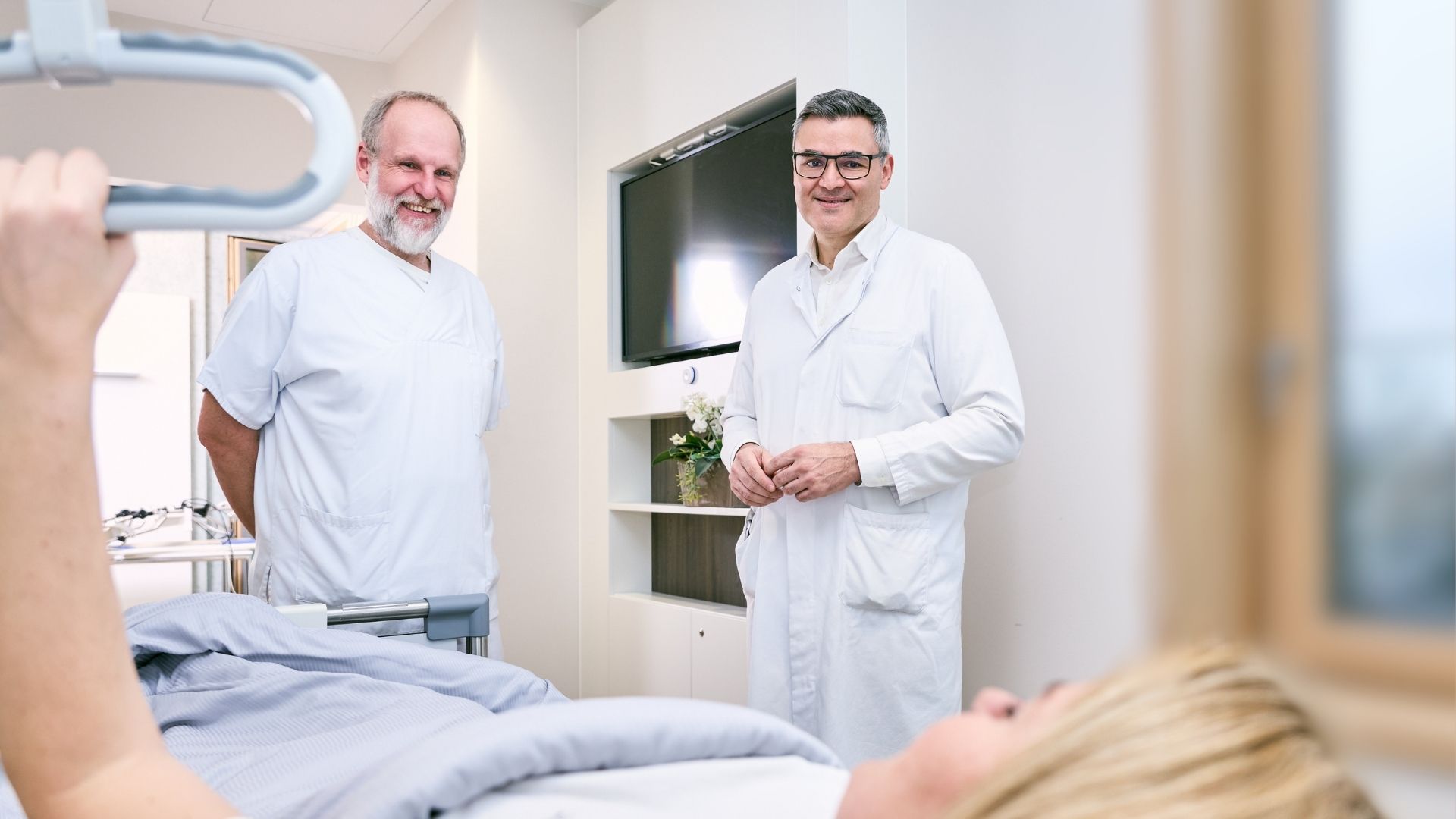 Dr. med. Dimitrios Vlachos und Pflegekraft bei der Mobilisation einer Patientin am ersten Tag nach der Hüft-OP