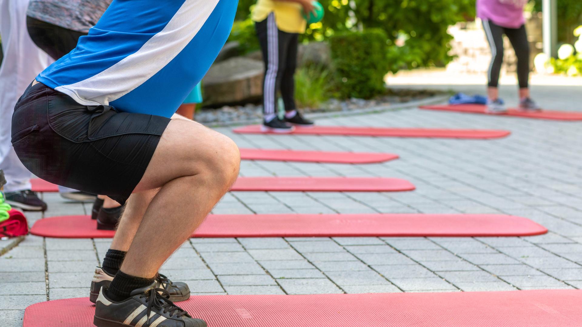 Eine Gruppe von Patienten bei dem Ausführen von Übungen für Hüfte, Knie und Fuß.