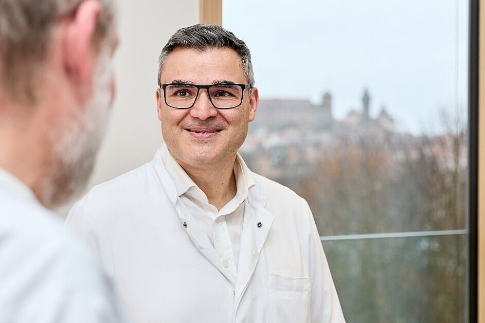 Dr. med. Dimitrios Vlachos im Gespräch mit einem Patienten in der Hüftsprechstunde der DR. ERLER KLINIKEN Nürnberg