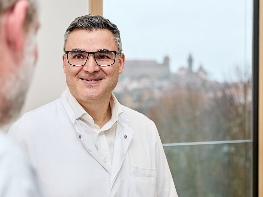 Dr. med. Dimitrios Vlachos im Gespräch mit einem Patienten in der Hüftsprechstunde der DR. ERLER KLINIKEN Nürnberg