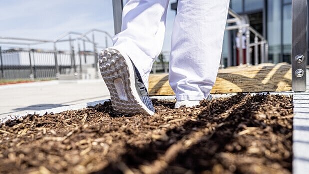Eine Person läuft über Rindenmulch im Rahmen des Reha-Rundweges. 